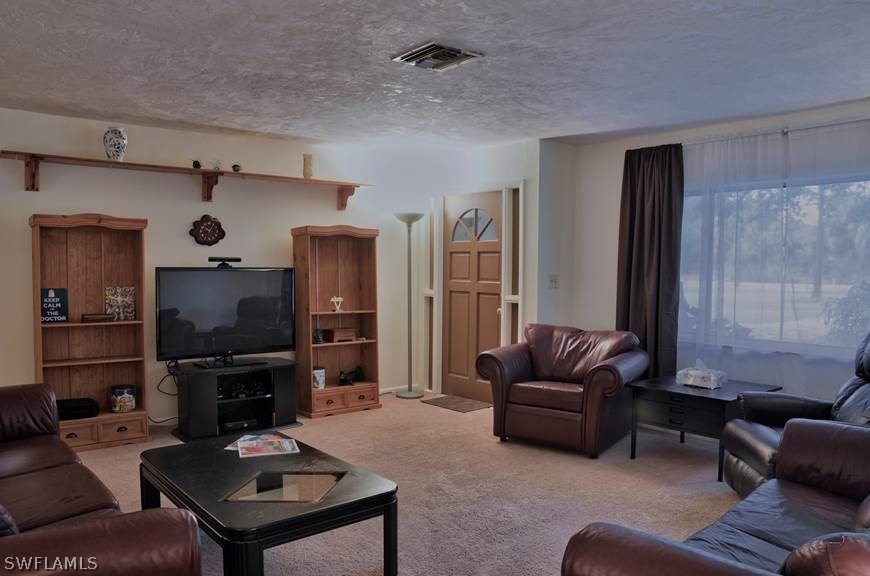 23081 North River Road Alva, FL 33920 - Photo 5 of 25 a living room with furniture and a flat screen tv