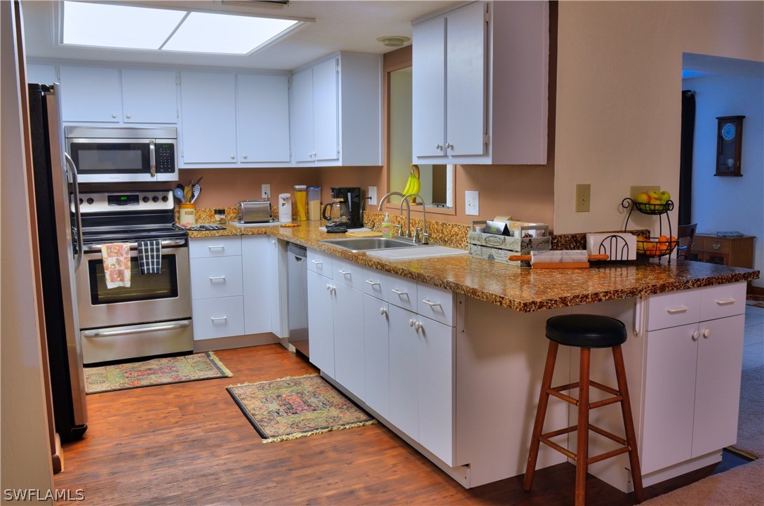 23081 North River Road Alva, FL 33920 - Photo 6 of 25 a kitchen with stainless steel appliances granite countertop a stove a sink dishwasher and a refrigerator