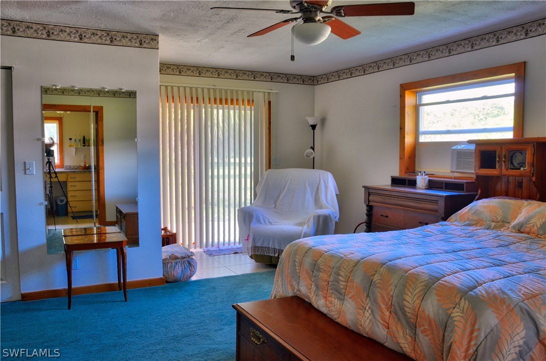 23081 North River Road Alva, FL 33920 - Photo 10 of 25 a bedroom with two beds and a chandelier