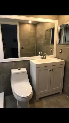 a bathroom with a sink a toilet and mirror