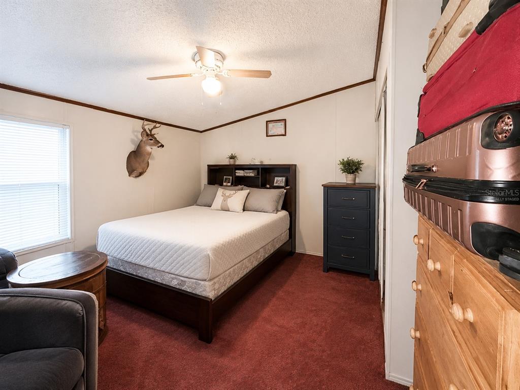 2665 Absher Road St. Cloud, FL 34771 - Photo 24 of 27 a bedroom with a bed and a chandelier
