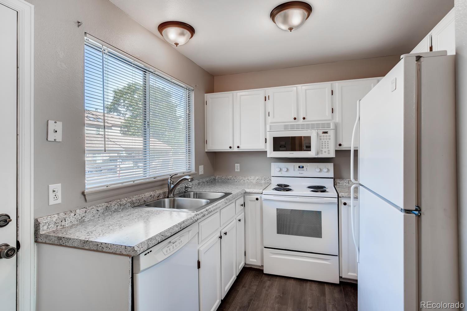862 Summer Drive Highlands Ranch, CO 80126 - Photo 2 of 21 a kitchen with granite countertop white cabinets and white appliances