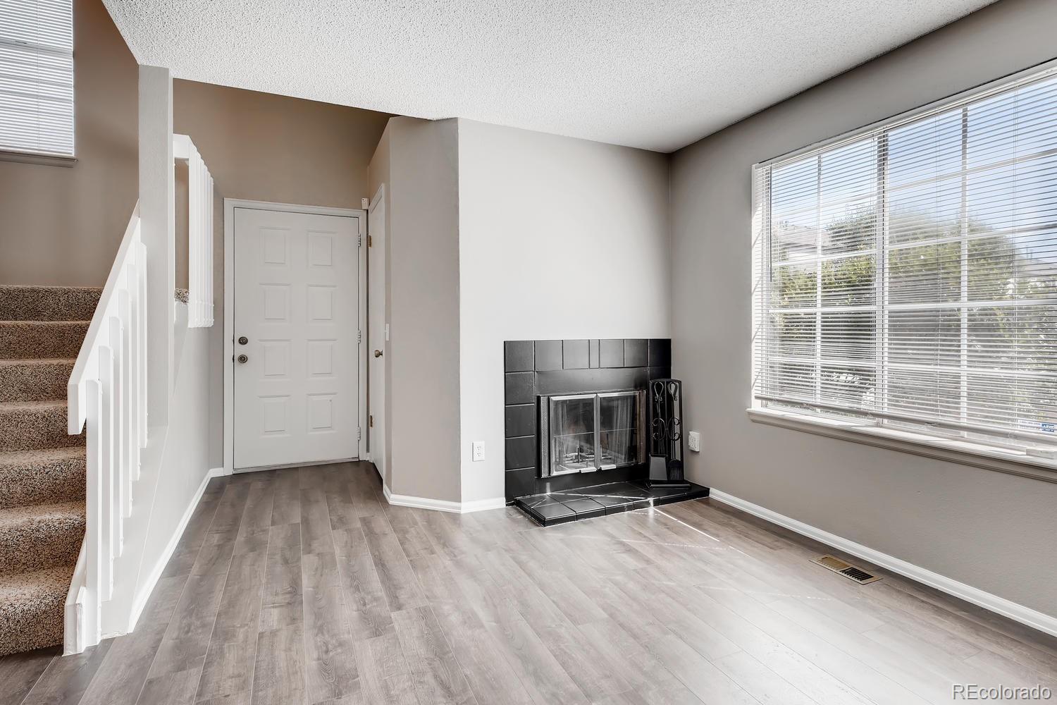 862 Summer Drive Highlands Ranch, CO 80126 - Photo 5 of 21 an empty room with a fireplace and wooden floor