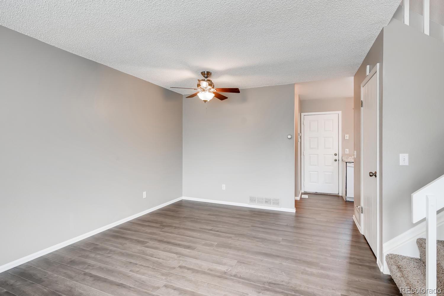 862 Summer Drive Highlands Ranch, CO 80126 - Photo 7 of 21 a view of a room with wooden floor and a ceiling fan
