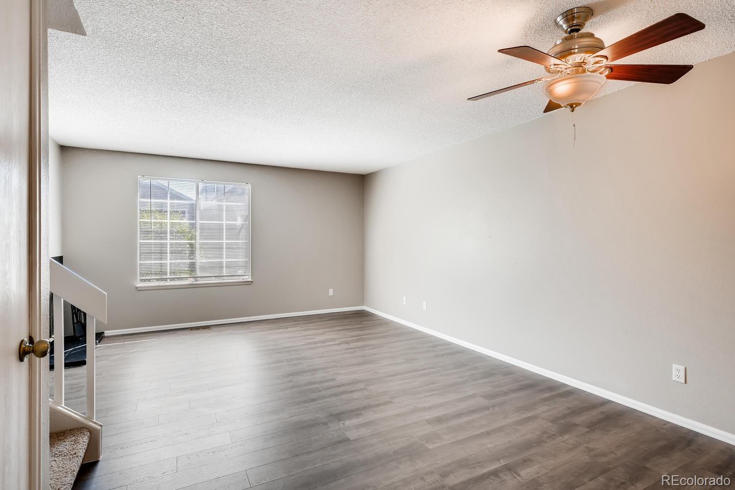 862 Summer Drive Highlands Ranch, CO 80126 - Photo 8 of 21 an empty room with wooden floor fan and windows