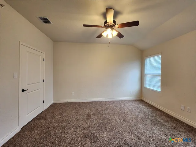 an empty room with a window and a fan