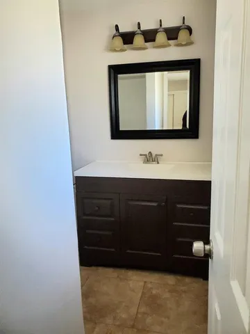 a bathroom with a sink a mirror and a vanity
