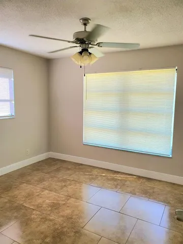 a view of a room with a ceiling fan and window