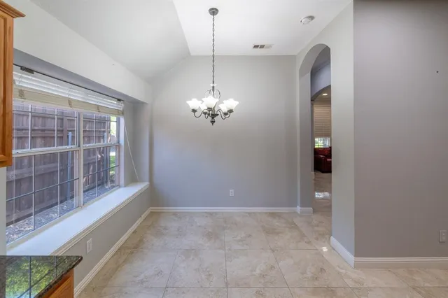 a view of a livingroom with a chandelier fan and windows