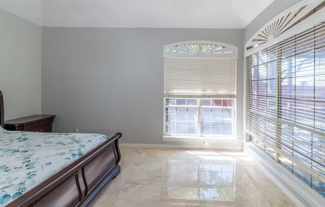 a view of a bedroom with a bed and wooden floor