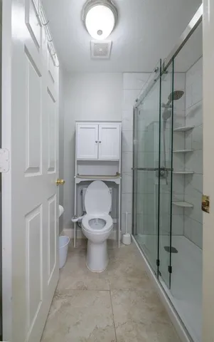 a bathroom with a toilet and a shower
