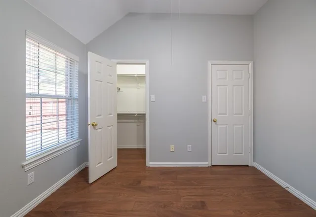 an empty room with windows and closet