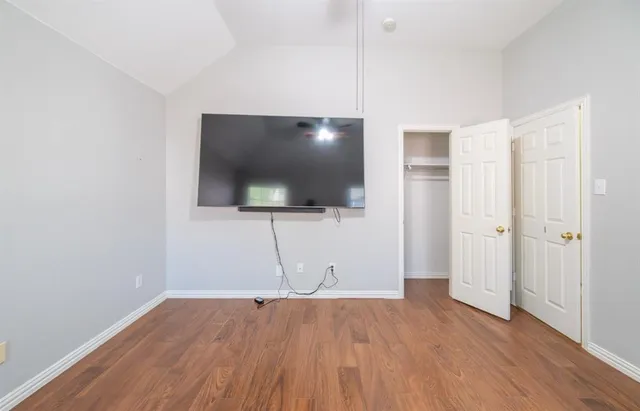 a view of a livingroom with wooden floor and a flat screen tv