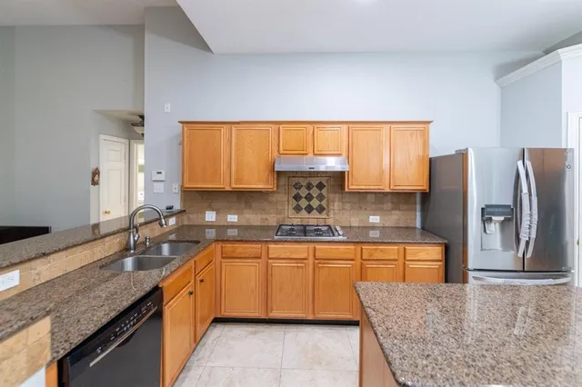 a large kitchen with stainless steel appliances granite countertop a sink stove and refrigerator