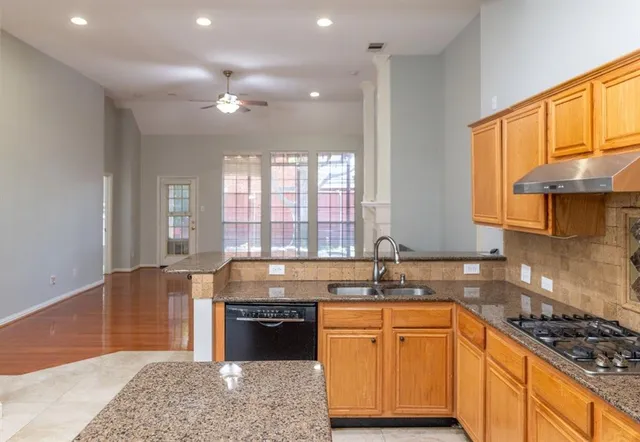 a kitchen with stainless steel appliances granite countertop a sink stove and cabinets