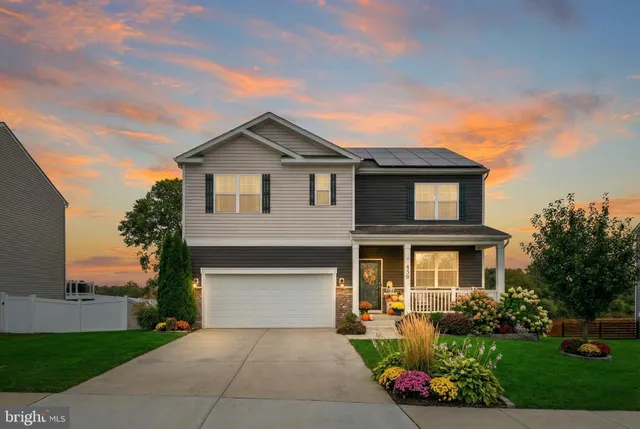 a front view of a house with a yard and potted plants