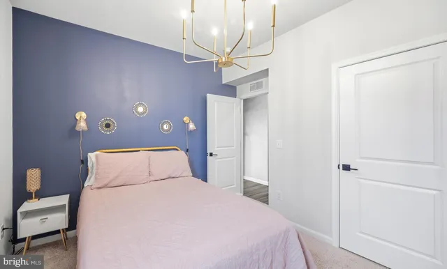 a bedroom with a bed a dresser and a flat screen tv