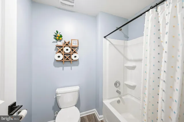 a living room with furniture a flat screen tv and a refrigerator