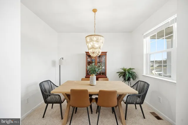 a kitchen with stainless steel appliances granite countertop a dining table chairs stove and refrigerator