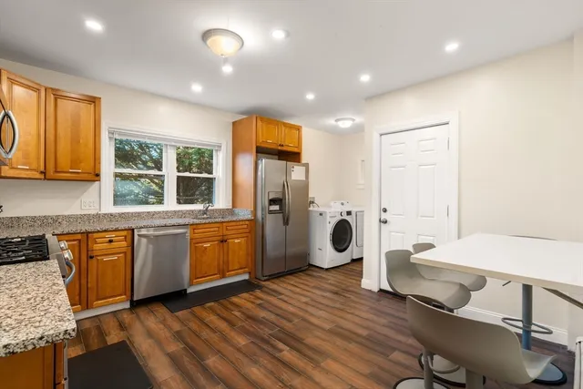 a kitchen with a sink a refrigerator and wooden cabinets