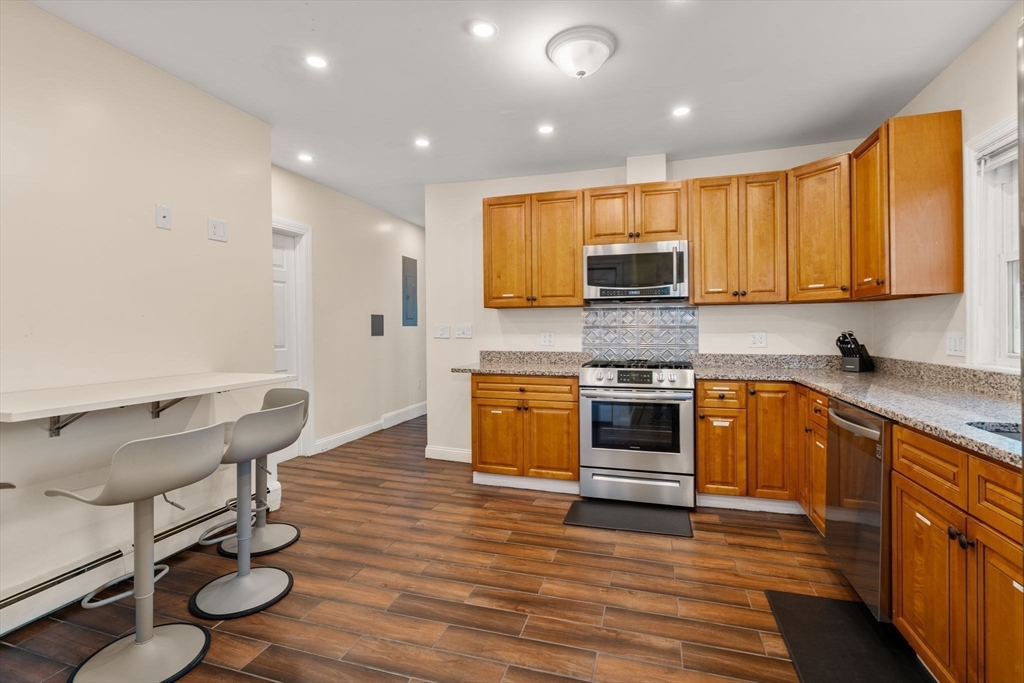 19 Carmen Street, Unit 2 Boston, MA 02121 - Photo 7 of 18 a kitchen with wooden floors and a stove