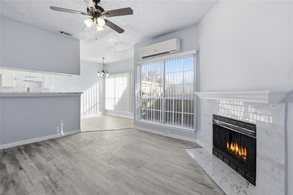 a view of an empty room with a fireplace and a window