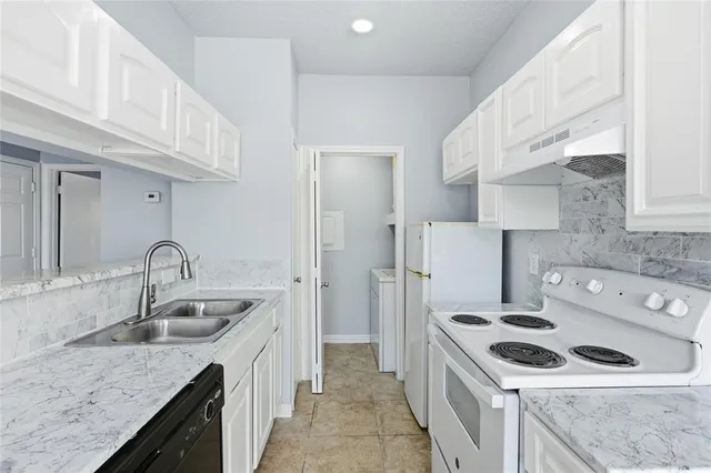 a kitchen with a sink stove top oven and refrigerator