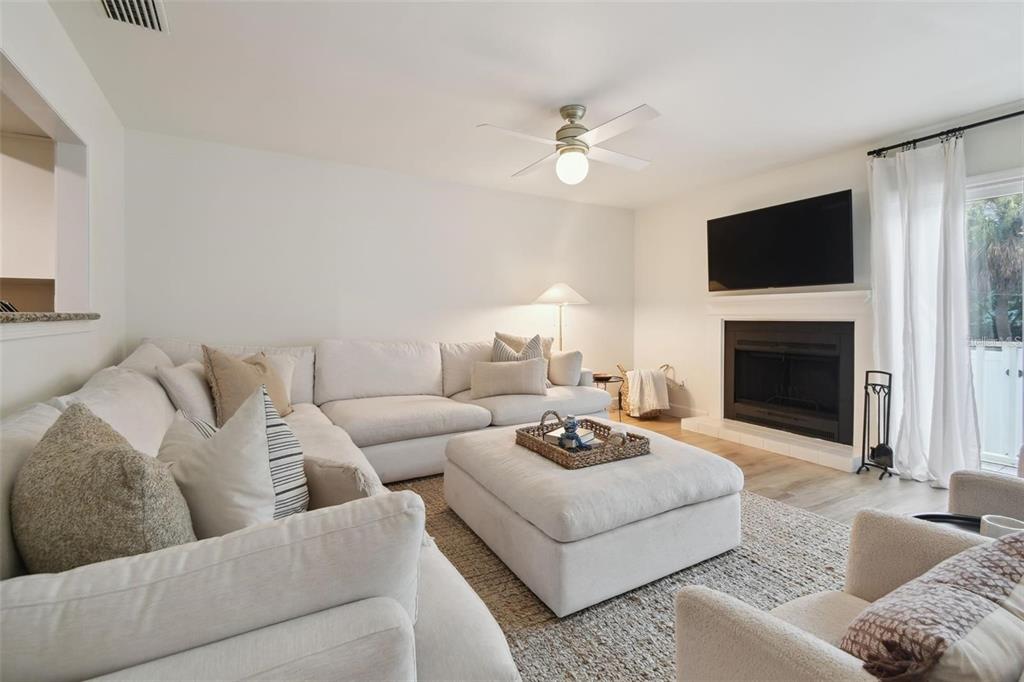 4835 West Flamingo Road Tampa, FL 33611 - Photo 19 of 51 a living room with furniture a flat screen tv and a fireplace