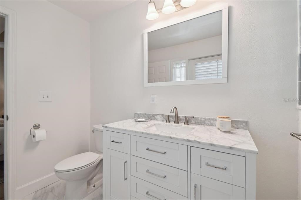 4835 West Flamingo Road Tampa, FL 33611 - Photo 26 of 51 a bathroom with a granite countertop toilet sink and mirror