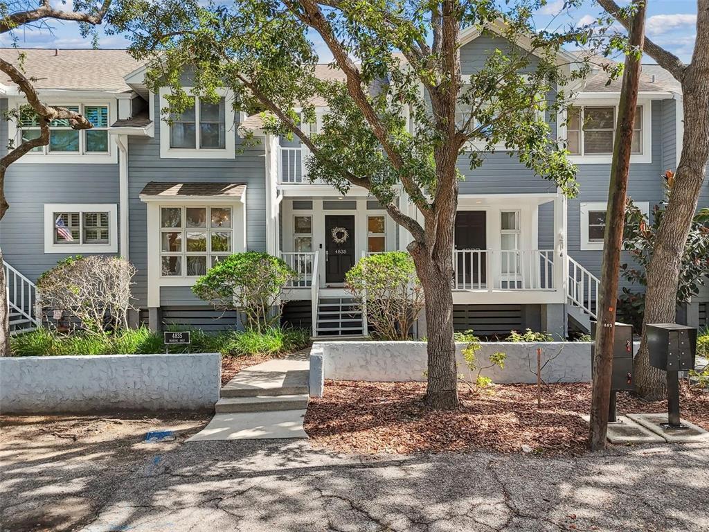 4835 West Flamingo Road Tampa, FL 33611 - Photo 3 of 51 a view of a brick house with large windows and plants