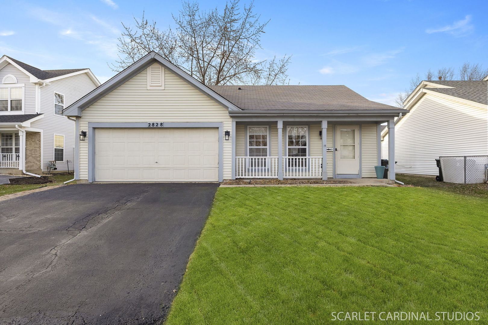a view of a white house with a small yard and a large tree