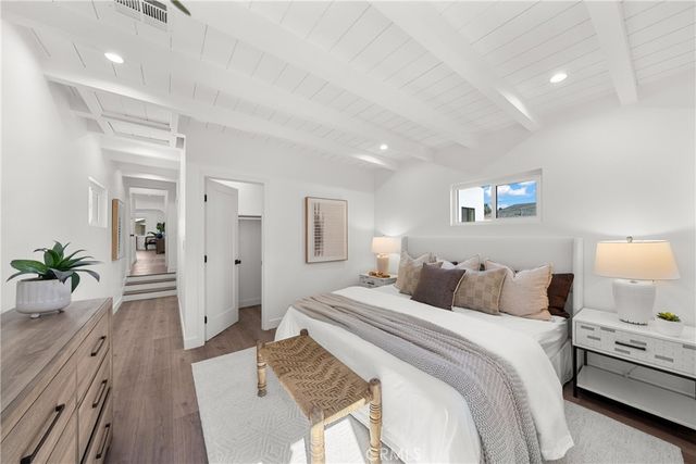a bedroom with a bed and a potted plant on dresser