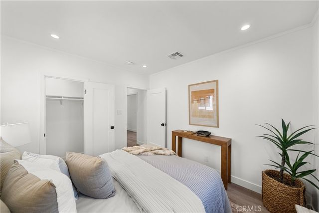 a bedroom with bed and a potted plant
