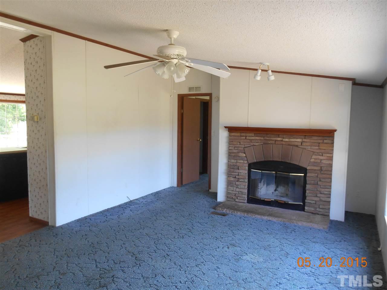 8714 South Creek Road Willow Spring, NC 27592 - Photo 3 of 9 a view of a livingroom with a fireplace and ceiling fan