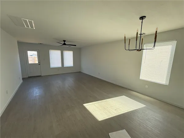 an empty room with windows and ceiling fan view