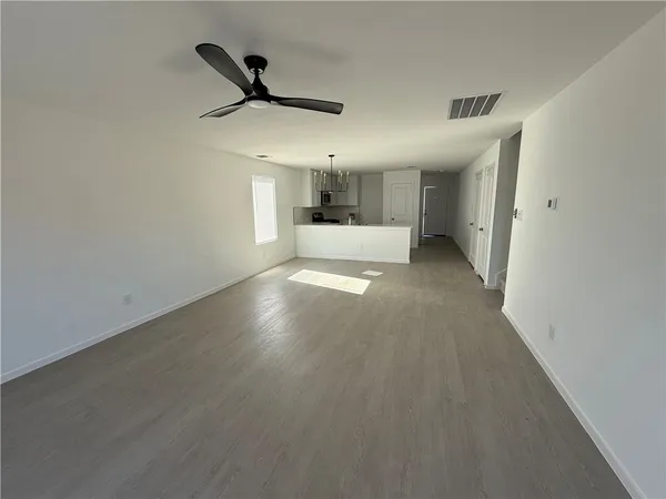 a view of a livingroom with a ceiling fan and wooden floor