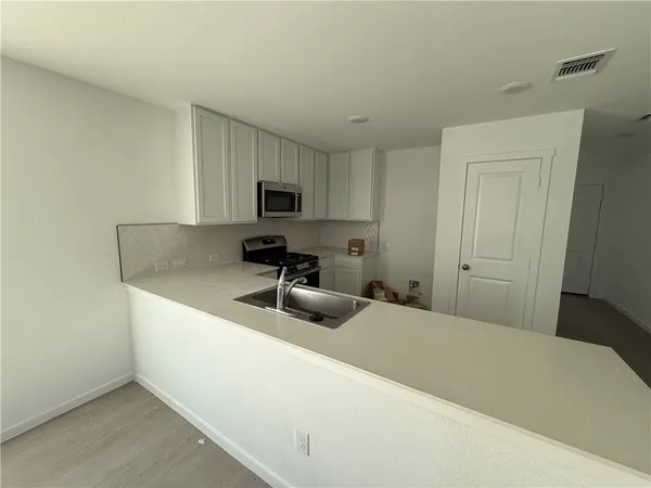 a kitchen with a sink a stove and a refrigerator