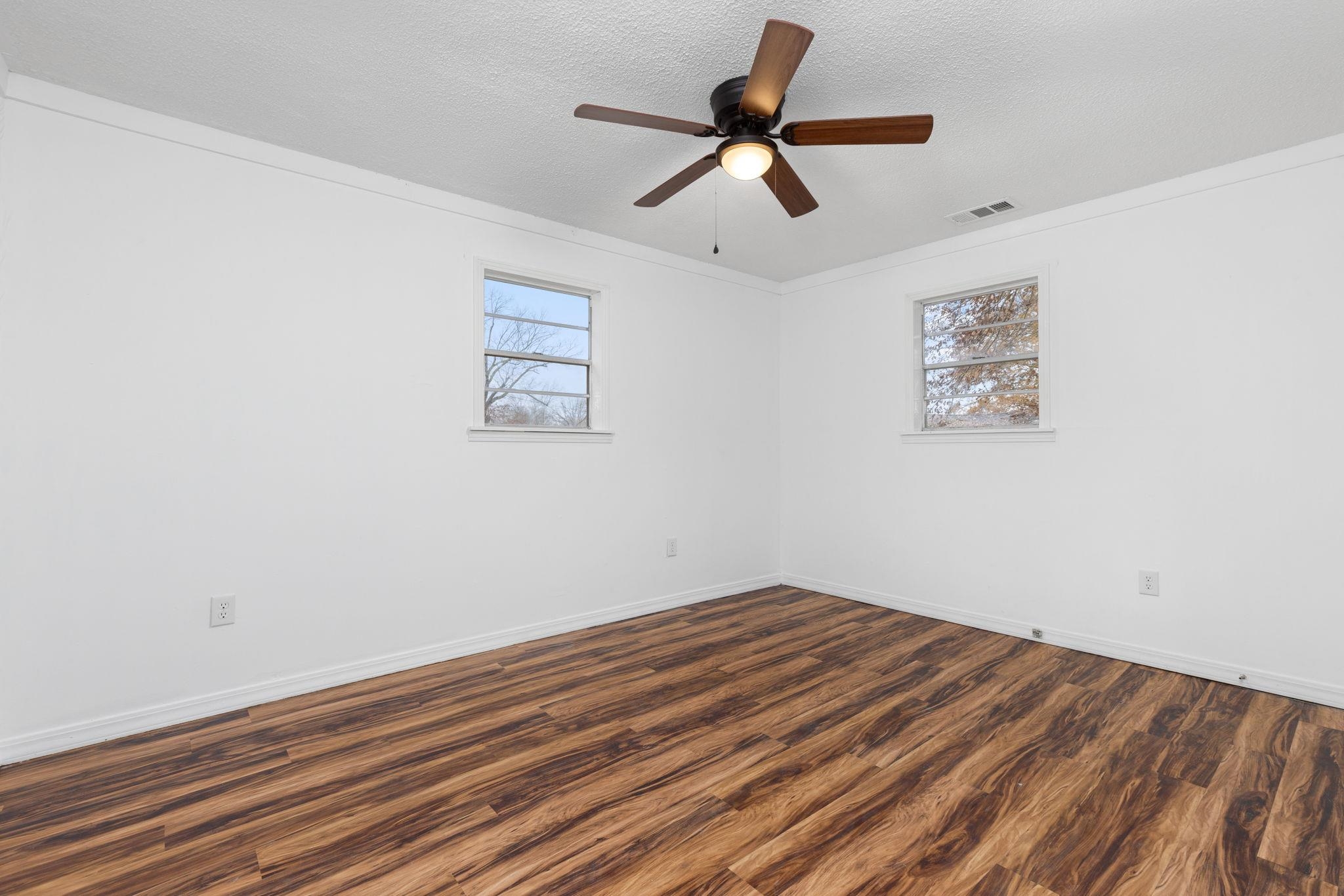 104 Huddleston Drive Ripley, MS 38663 - Photo 13 of 26 Spare room with a textured ceiling, ceiling fan, and dark hardwood / wood-style floors