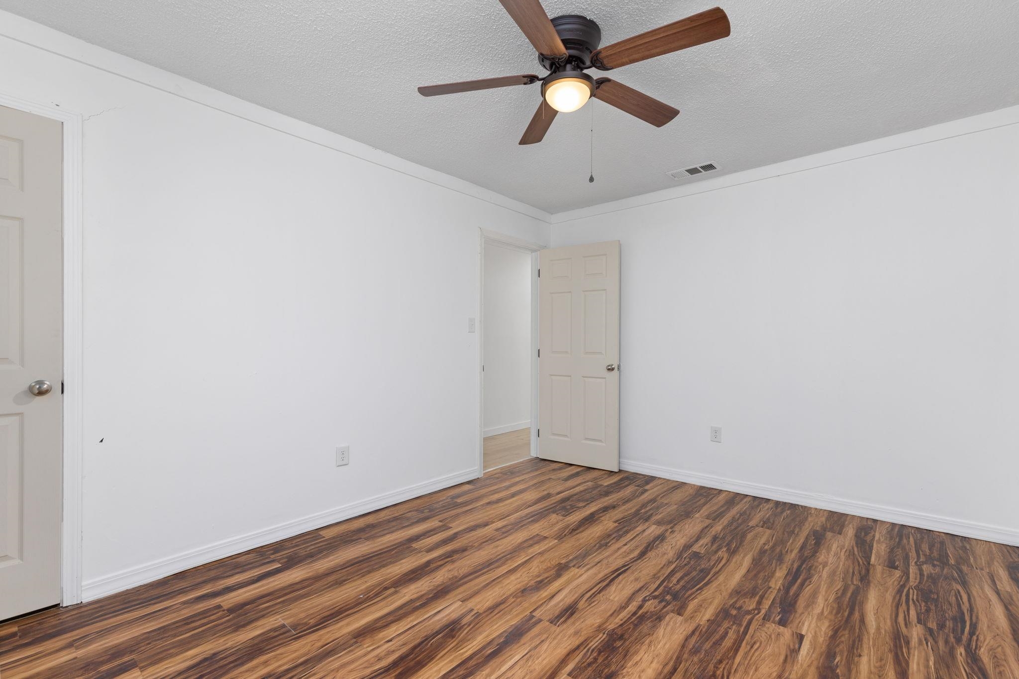 104 Huddleston Drive Ripley, MS 38663 - Photo 14 of 26 Spare room featuring a textured ceiling, dark hardwood / wood-style floors, and ceiling fan
