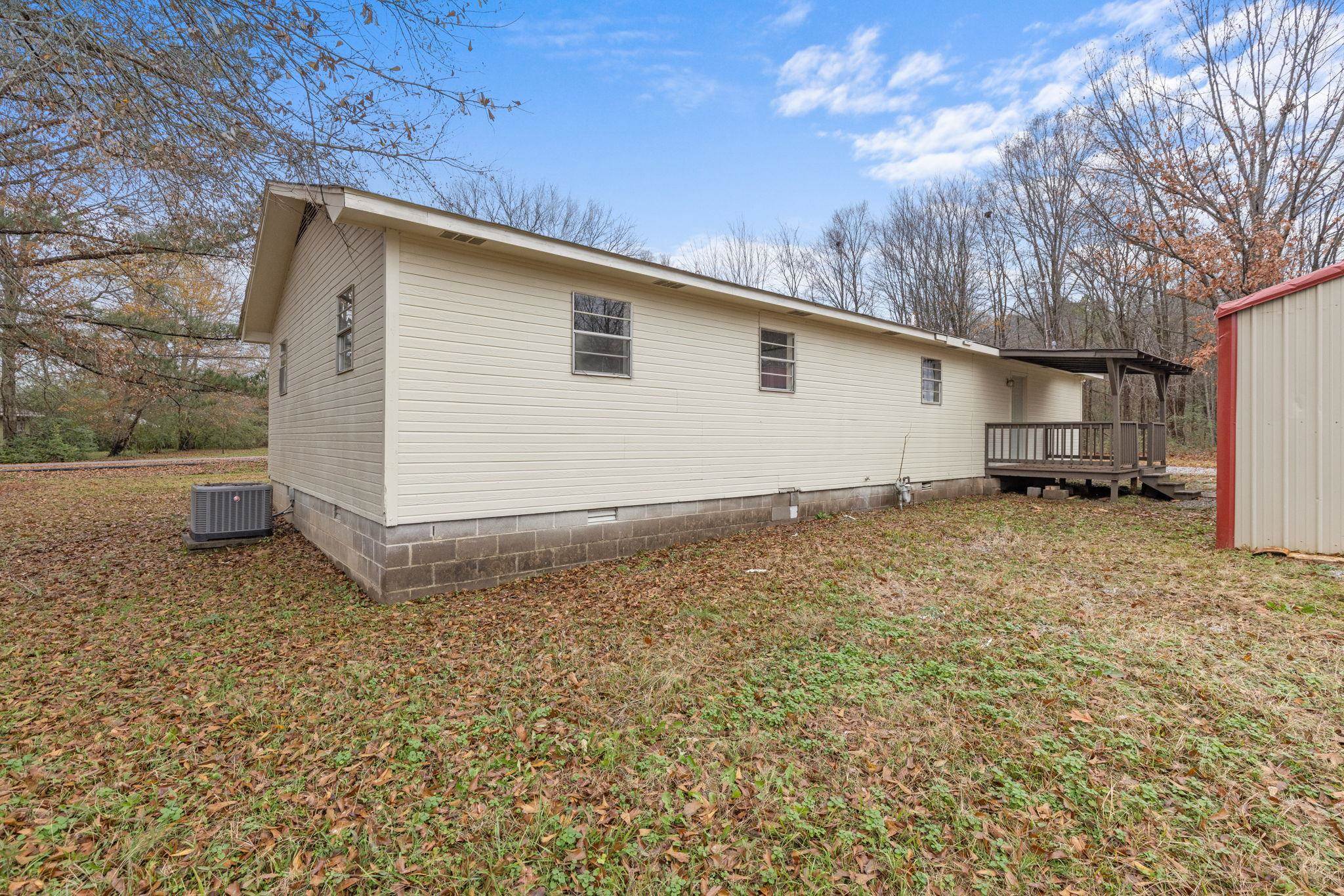 104 Huddleston Drive Ripley, MS 38663 - Photo 23 of 26 View of property exterior with central AC unit and a wooden deck
