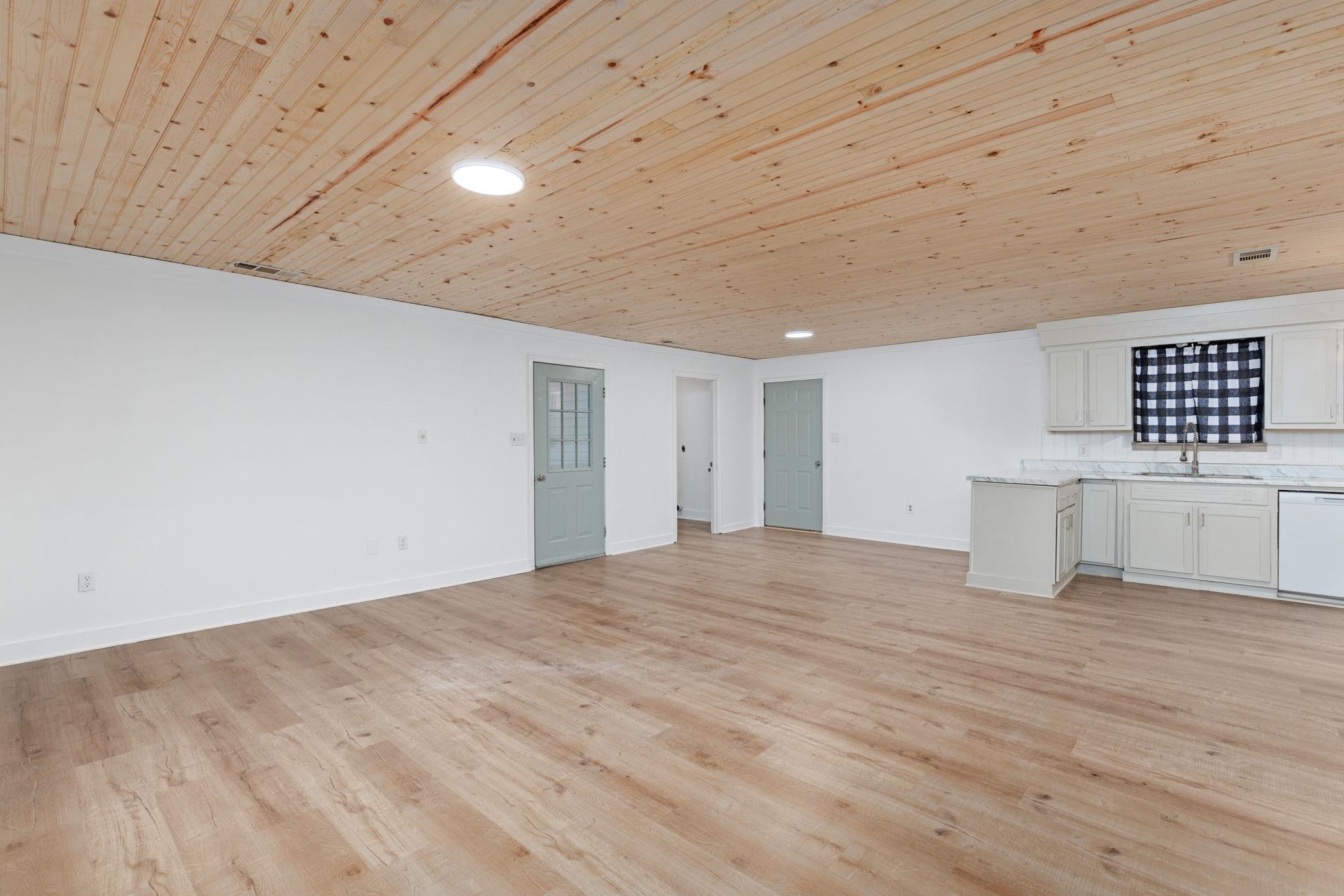 104 Huddleston Drive Ripley, MS 38663 - Photo 4 of 26 Unfurnished living room featuring light hardwood / wood-style flooring, wood ceiling, and sink