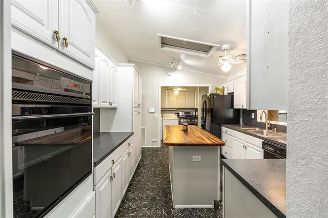 a view of an empty room with cabinet and wooden floor