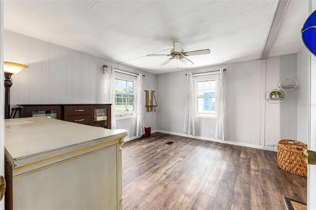 an empty room with windows and fan