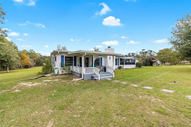 a backyard of a house with barbeque oven table and chairs