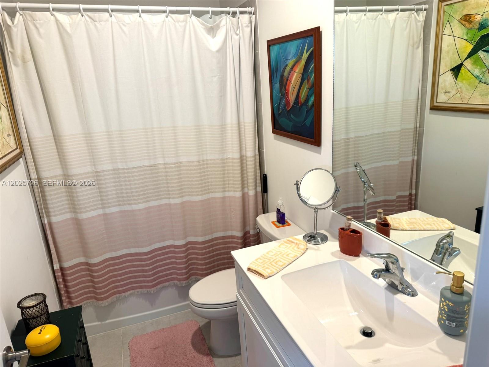 10020 Southwest 228th Terrace Miami, FL 33190 - Photo 9 of 22 a bathroom with a sink a toilet and shower curtain