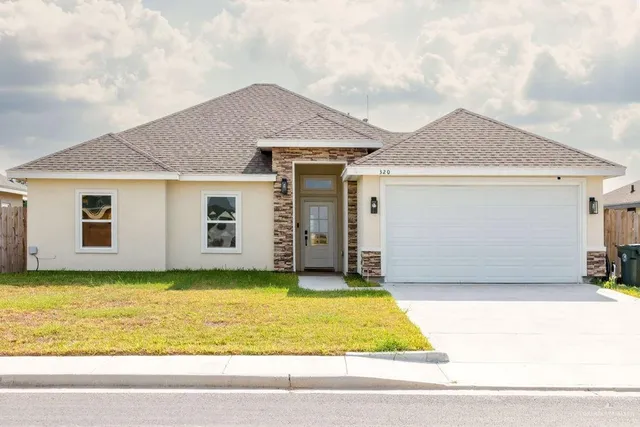 a view of a house with a yard and garage