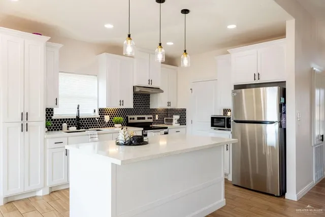 a kitchen with refrigerator a stove a sink and a center island