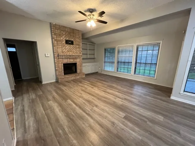 wooden floor fireplace and windows in an empty room