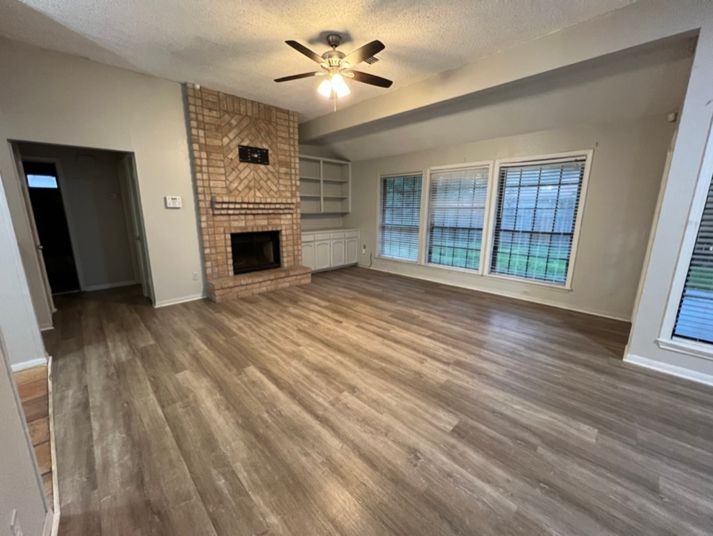 7309 Ridge Creek Drive Corpus Christi, TX 78413 - Photo 2 of 6 wooden floor fireplace and windows in an empty room
