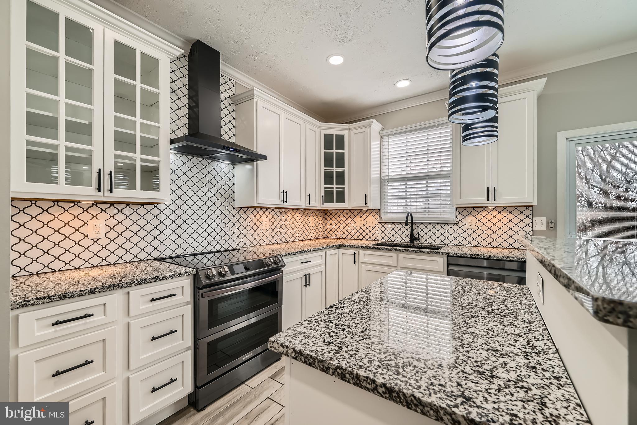 9655 Davison Road Middle River, MD 21220 - Photo 11 of 43 a kitchen with granite countertop a stove a sink and wooden cabinets